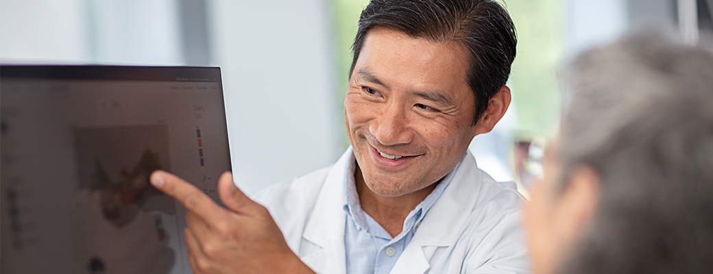 Image of hearing care professional showing an audiogram to a senior patient